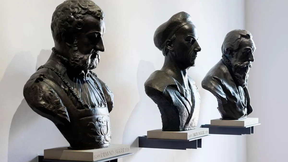 Drei schwarze Figuren auf einem Podest